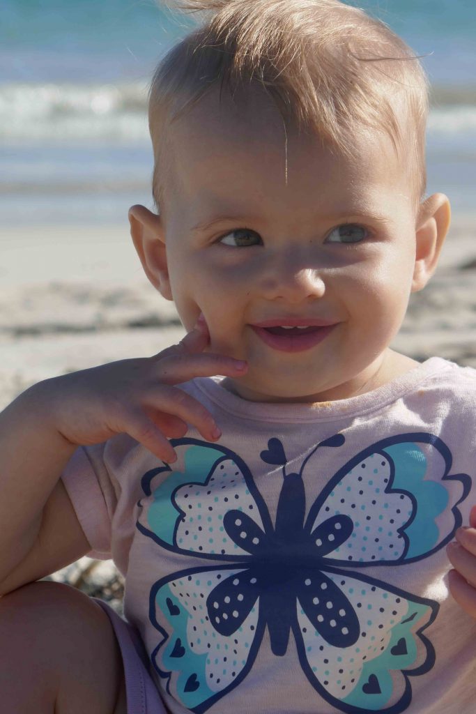 https://www.writteninwaikiki.com/10-tips-taking-better-photos-kids/ child smiling beach Waikiki Rockingham Western Australia