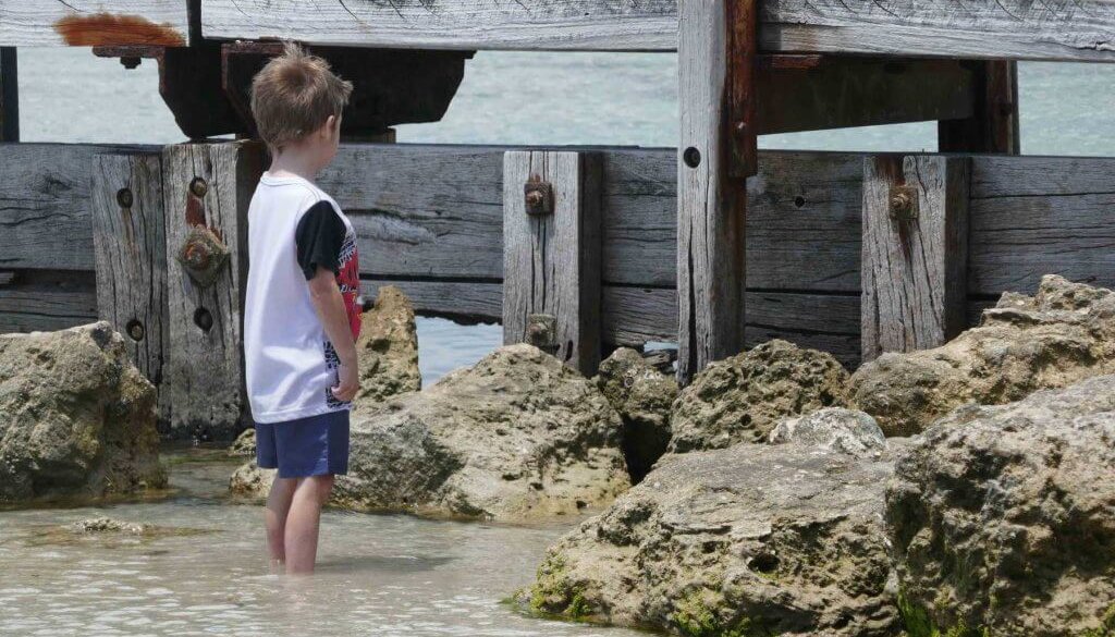 how to build self-esteem in kids child boy at beach staring at bridge