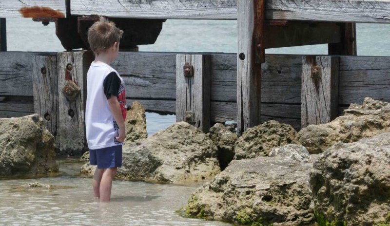 how to build self-esteem in kids child boy at beach staring at bridge