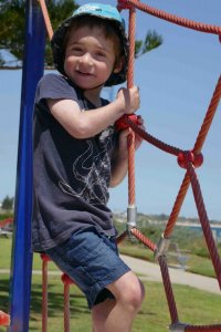 child boy playing on swings at park