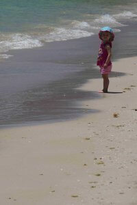 girl toddler standing on the beach 