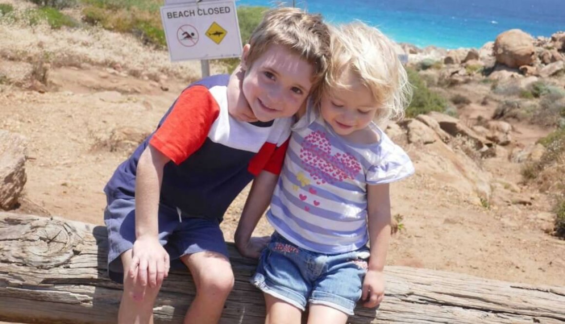 two kids being happy and smiling at the beach