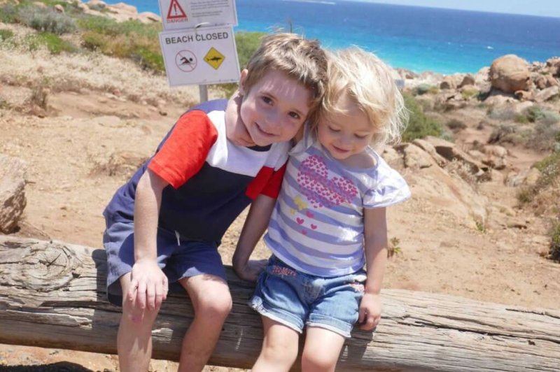 two kids being happy and smiling at the beach