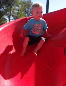 Child toddler going down slide not giving up