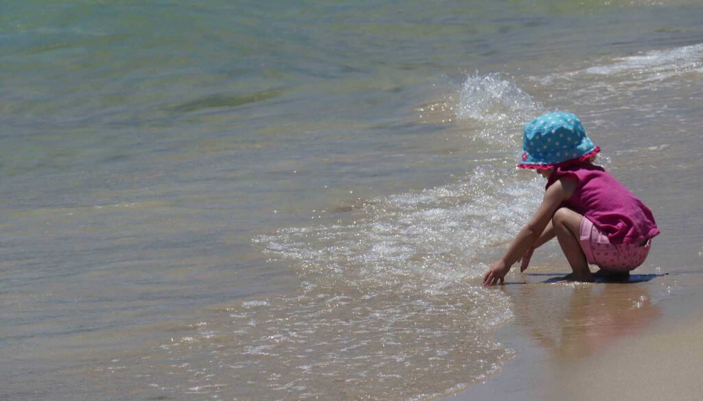 girl playing in water at the beach