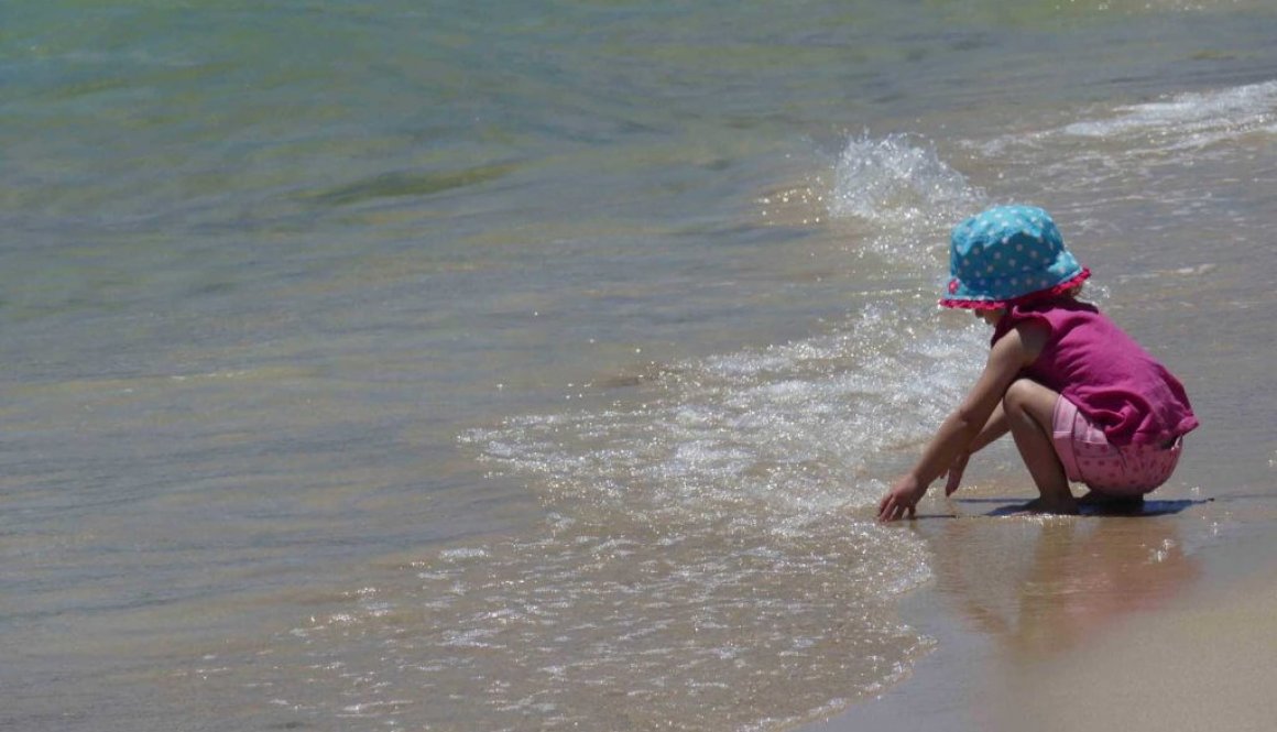 girl playing in water at the beach