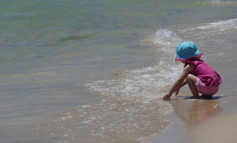 girl playing in water at the beach