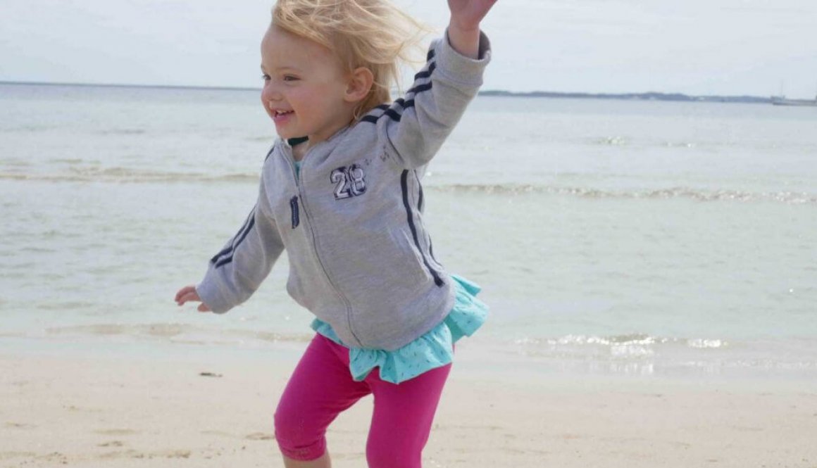 Girl happy jumping dancing at beach being herself