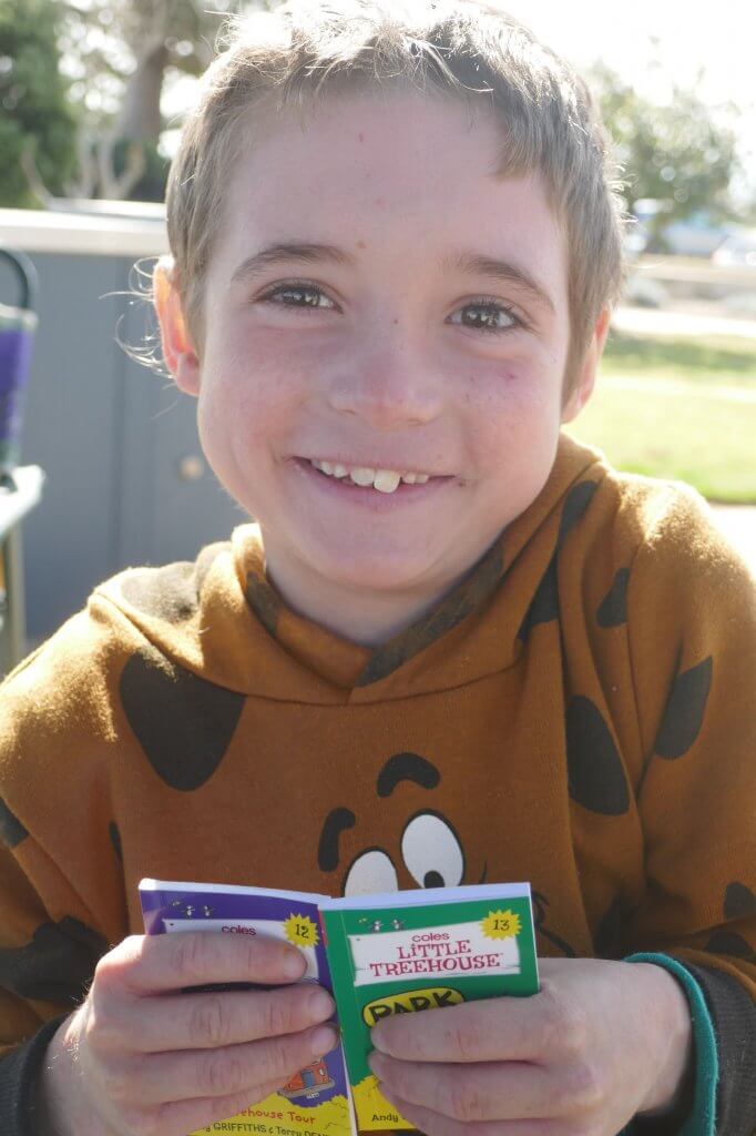 young boy smiling with books